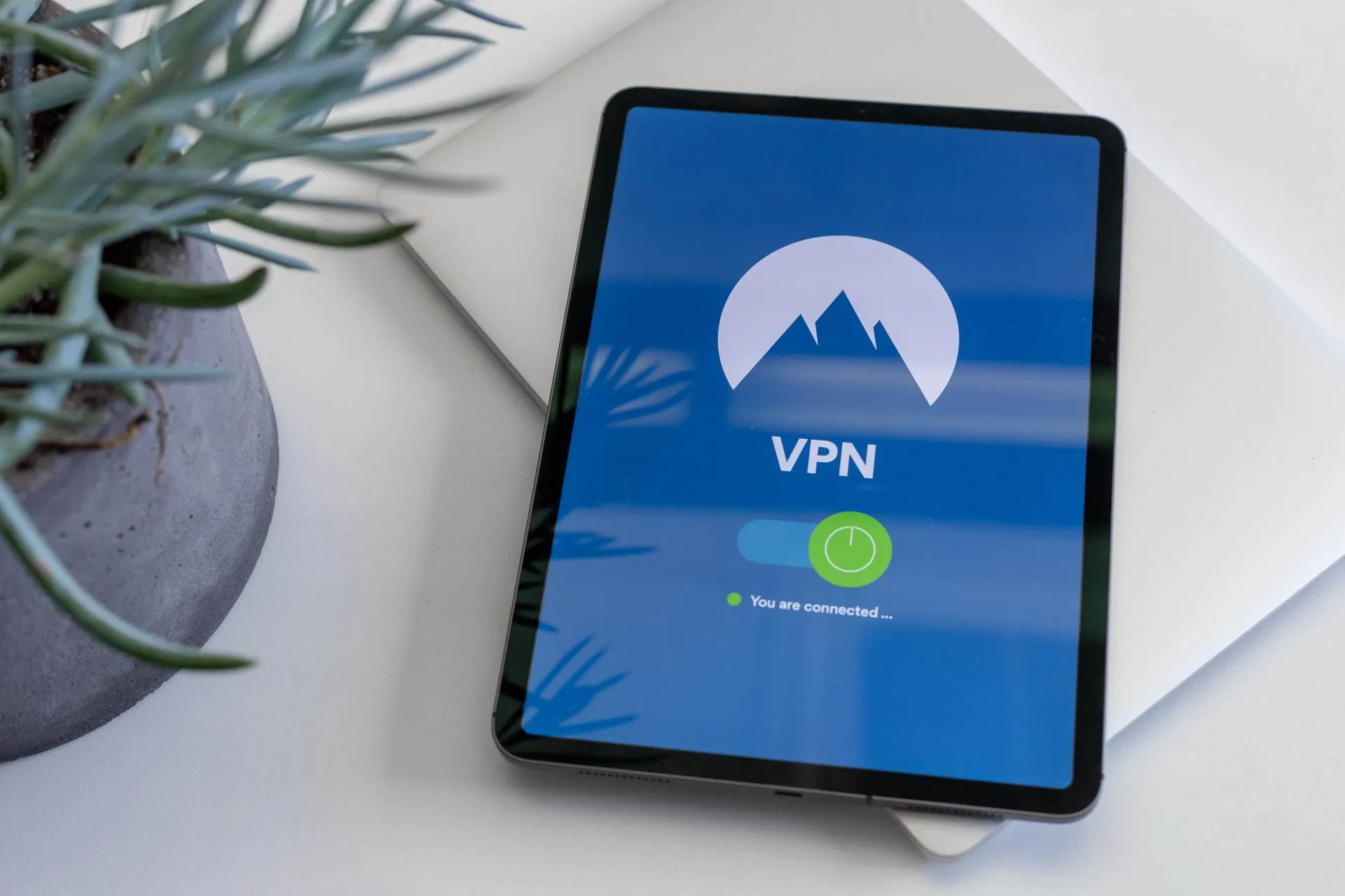 A tablet device next to a plant pot with the text VPN and a green on button